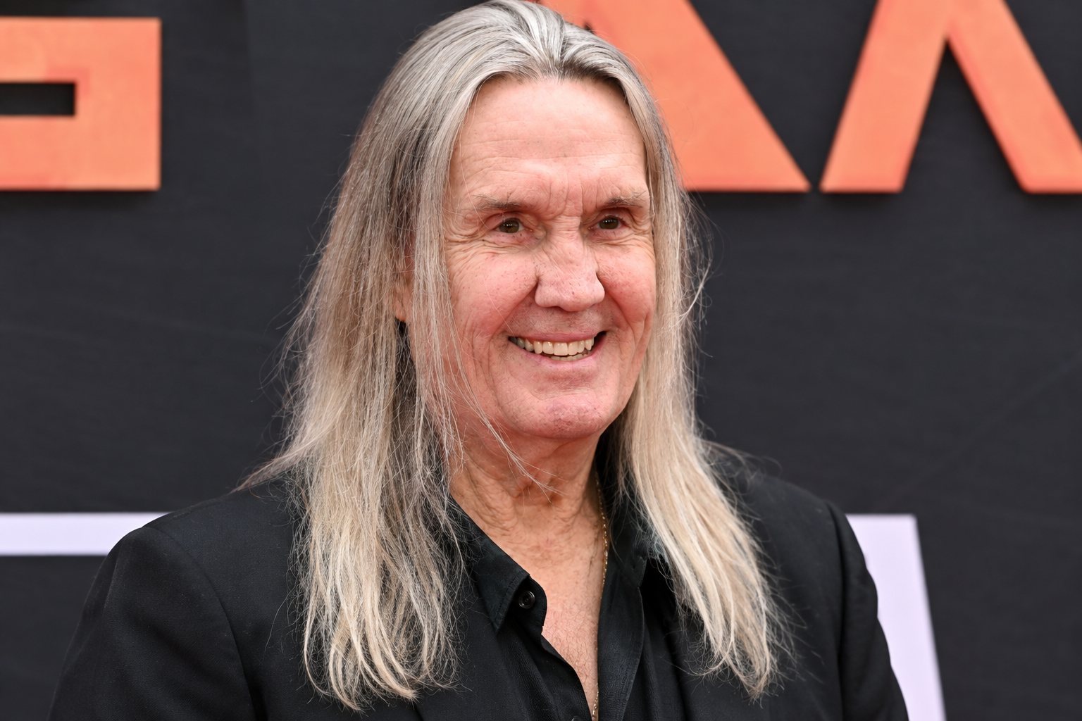 Nicko McBrain seated at a drum kit, portrait